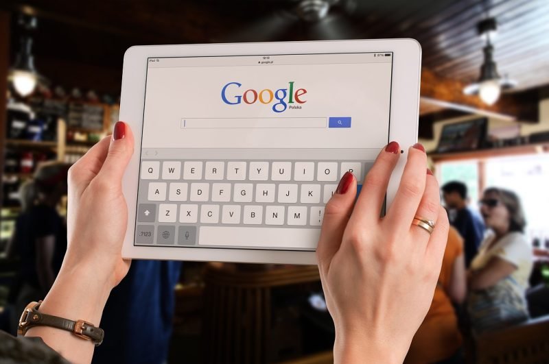 Une personne réalisant une recherche Google sur une tablette numérique